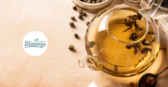 Top-down view of a glass teapot filled with Oolong tea and loose tea leaves, surrounded by dried tea pearls on a rustic surface with the Blissenza logo.